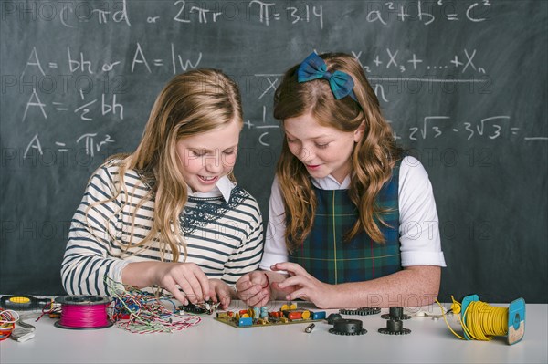 Caucasian students building vehicle in science class