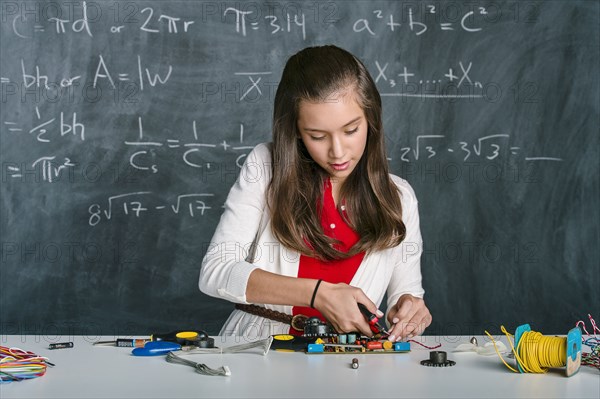 Hispanic student building vehicle in science class