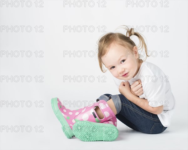 Crouching girl wearing rain boots