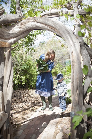 Mother and son carrying plants in backyard