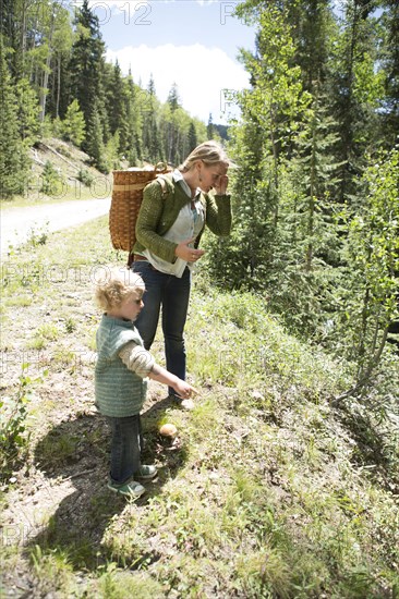 Mother and son exploring on forest hillside