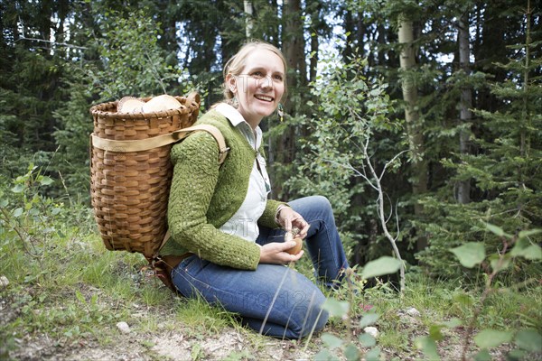 Woman foraging for mushrooms in forest