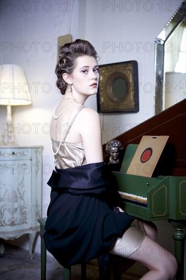 Woman sitting at piano in ornate living room