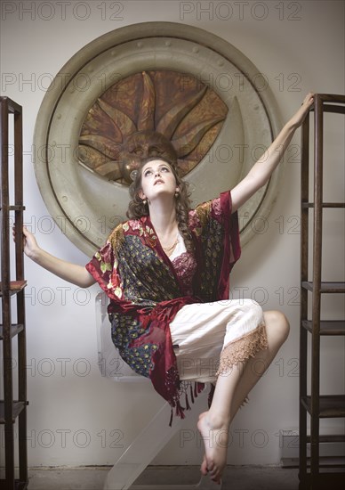 Woman floating between empty bookshelves in ornate room