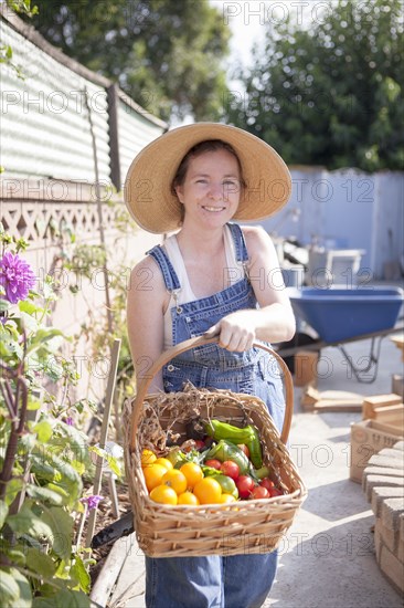 Mixed race farmer gathering produce in garden