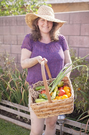 Mixed race gardener gathering vegetables in garden