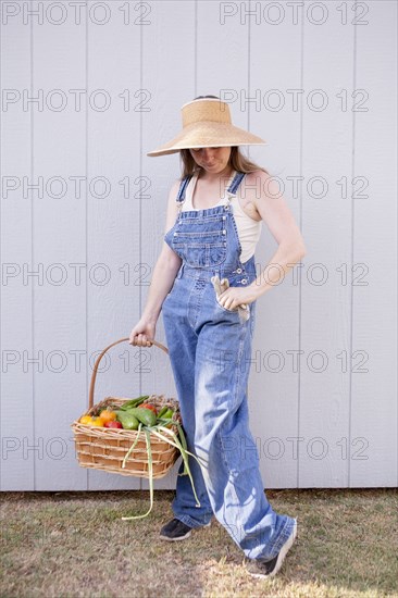 Mixed race farmer holding basket of vegetables