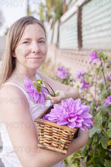 Mixed race woman picking flowers in garden