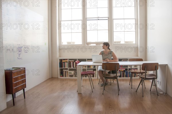 Caucasian businesswoman working on laptop in office