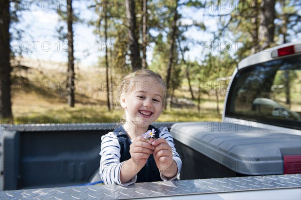 Caucasian girl playing in truck bed