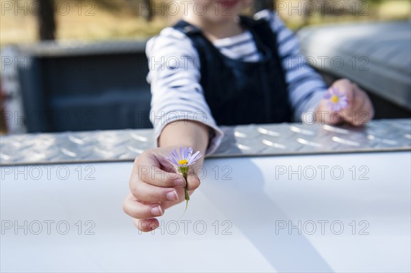 Caucasian girl holding flowers in truck bed