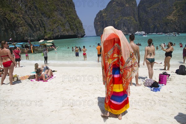 Woman in traditional headscarf standing on beach