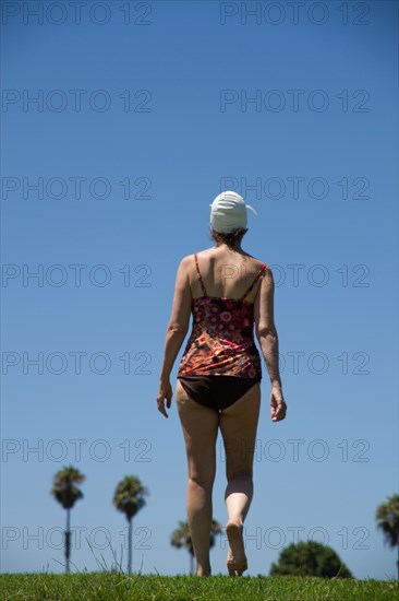 Caucasian woman wearing bathing suit in grass