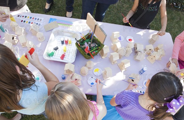 Children doing arts and crafts in backyard