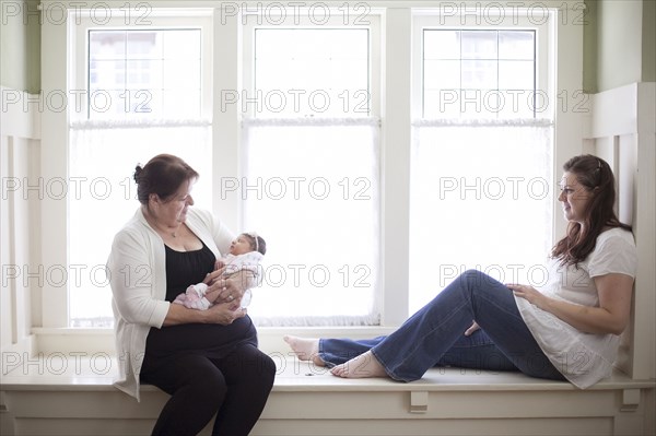 Three generations of Caucasian women in windowsill