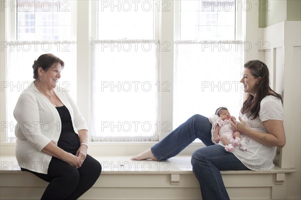 Three generations of Caucasian women in windowsill