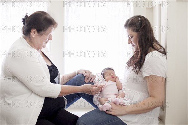 Three generations of Caucasian women in windowsill