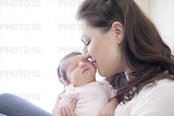 Caucasian mother kissing baby girl