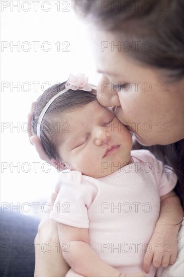 Caucasian mother kissing baby girl