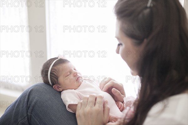 Caucasian mother cradling baby girl