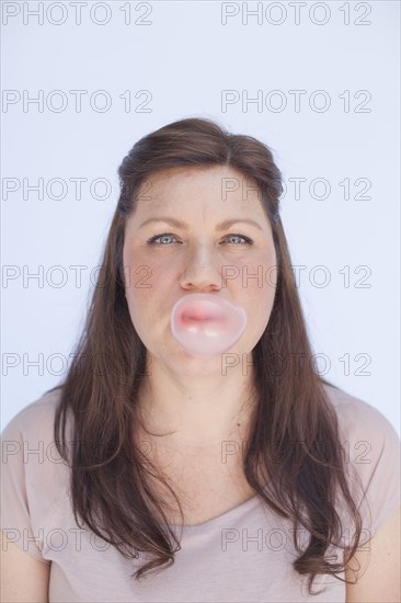 Caucasian woman blowing bubble with gum