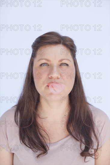 Caucasian woman blowing bubble with gum