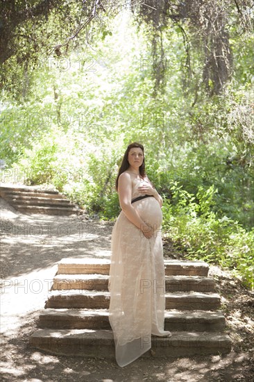 Pregnant Caucasian woman standing on hillside steps