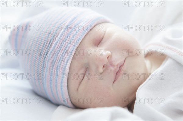 Caucasian newborn girl wearing cap