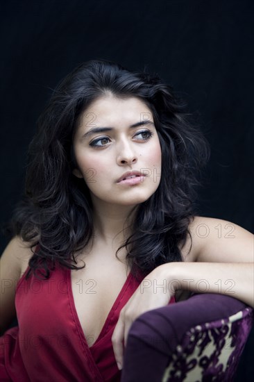 Mixed race woman leaning on armchair