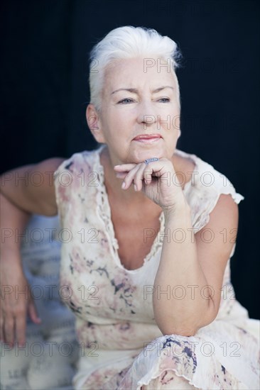 Caucasian woman resting chin in hand