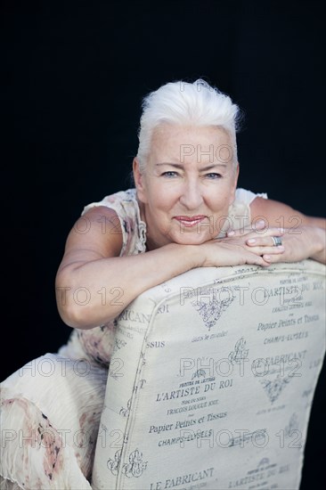 Caucasian woman leaning on chair back