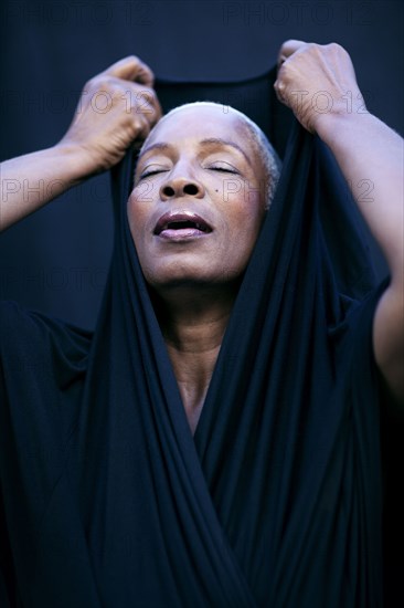 Close up of woman covering her head with shawl