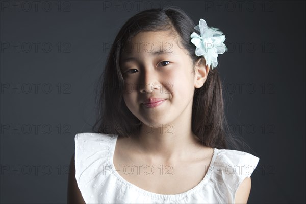 Smiling Asian girl wearing flower in her hair