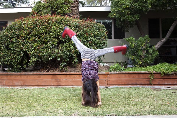 Mixed race girl doing cartwheels in backyard