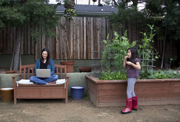 Mother and daughter relaxing in backyard