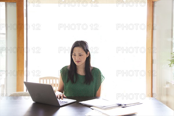 Korean woman paying bills on laptop