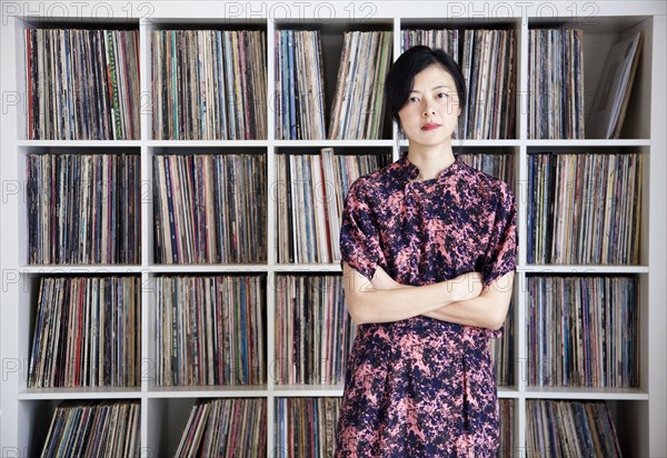 Taiwanese woman standing near record collection