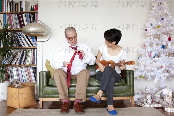 Couple enjoying gifts near Christmas tree