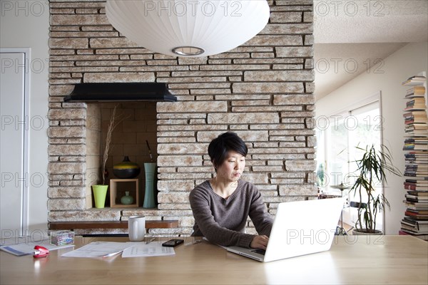 Japanese woman paying bills on laptop