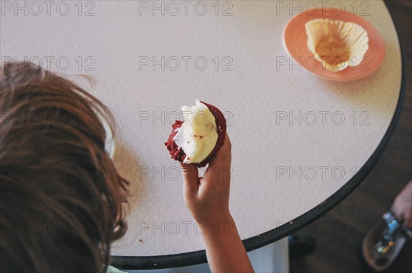 Teenage boy eating cupcake