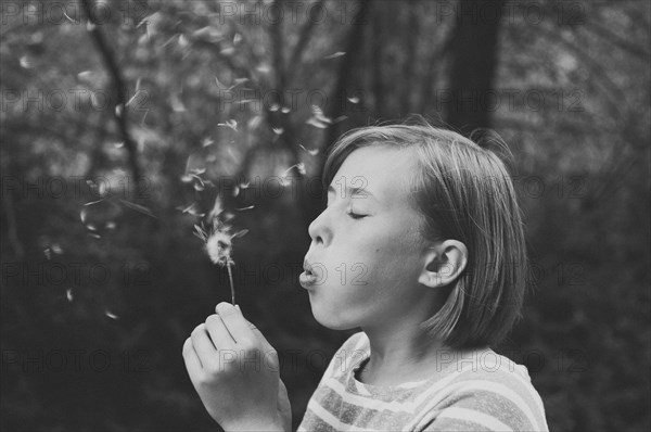 Girl blowing dandelion seeds