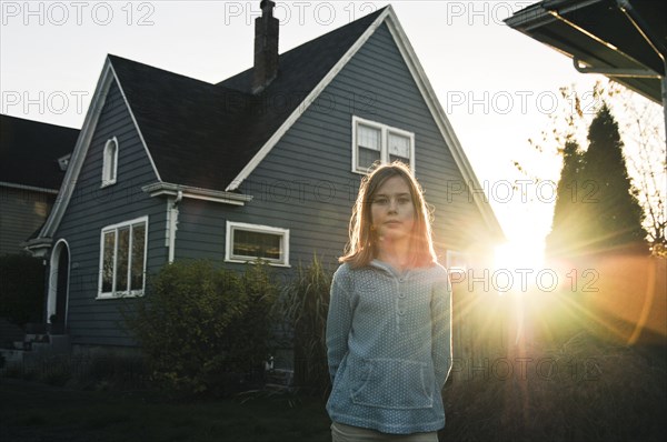 Girl smiling near house at sunset