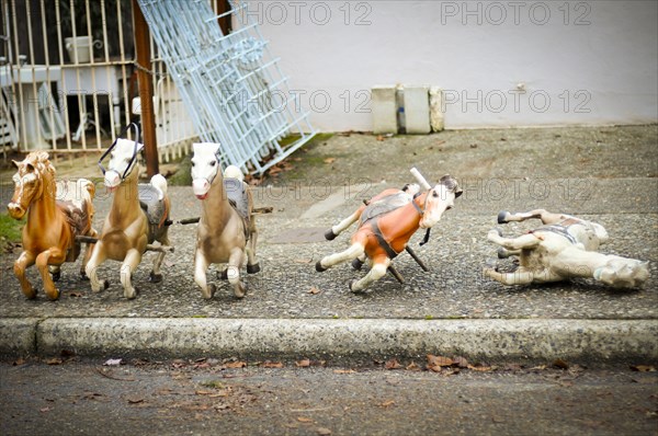 Toy rocking horses on city sidewalk