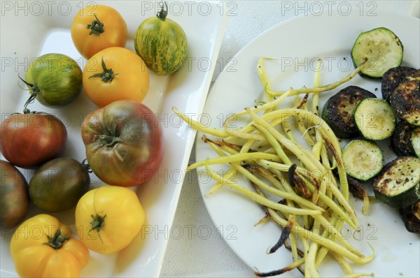 Plates of fresh tomatoes and grilled vegetables