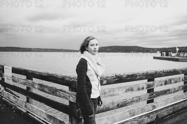Girl standing on wooden dock at lake