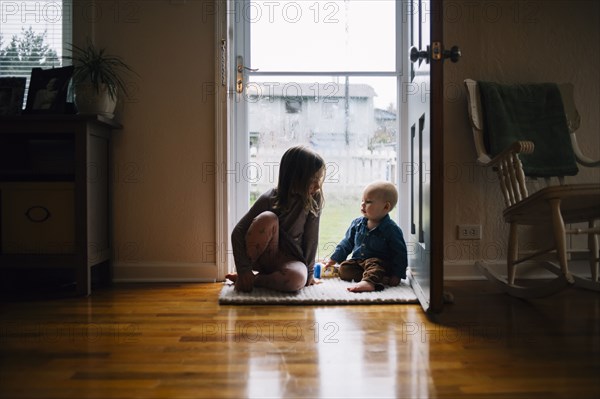 Brother and sister sitting in doorway