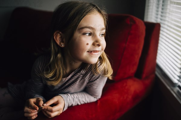 Smiling girl sitting in armchair