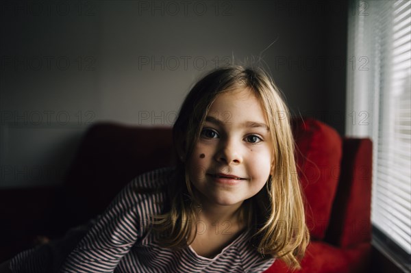 Smiling girl sitting in armchair