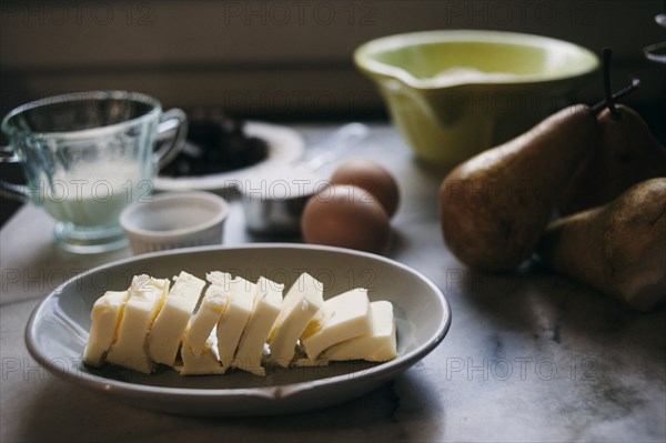 Close up of baking ingredients and pears on marble counter