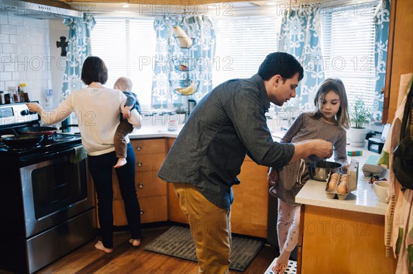 Parents cooking with children in kitchen